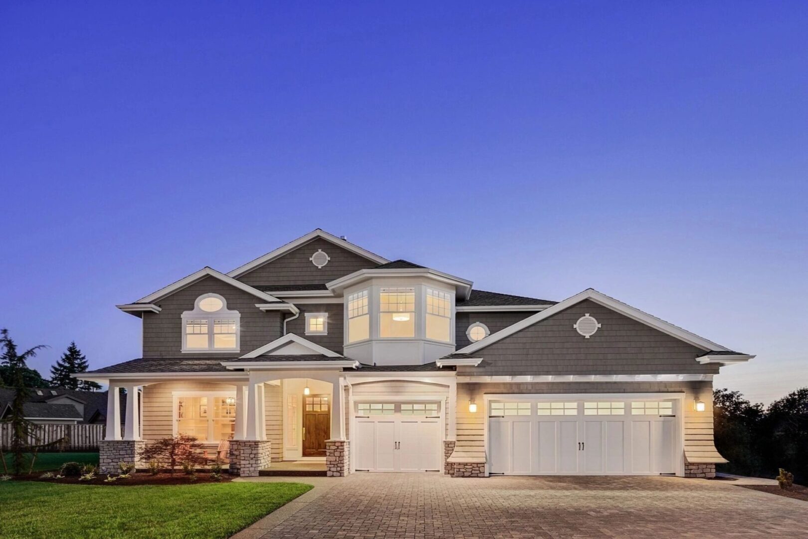 A large house with two garage doors and a porch.